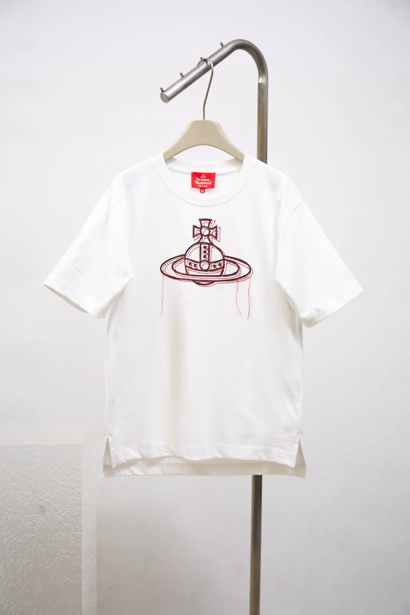 vivienne Westwood Queen Mother's new 2025 spring and summer Japanese limited-edition tassel embroidered short-sleeved T-shirt. The appearance of the appearance reveals the uninhibited image and high street trends. It has a loose and casual style, a short front and long back design, a small slit on the hem on both sides, and the iconic Saturn shape on the chest. The cross crown ball is added with a very futuristic satellite ring, just like Saturn, which collides with the prominent colors of the clothes. The non-overlapping Saturn pattern is outlined with red embroidery, which is visually dazzling. It also has a few tassels to complete the unconventional personality. 240g 32 count high-density double yarn cotton, comfortable and breathable fabric Size: XS-L Color: white, black